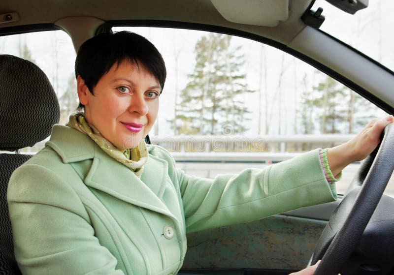 La donna graziosa conduce un'automobile fotografie stock La donna graziosa conduce un'automobile fotografie stock