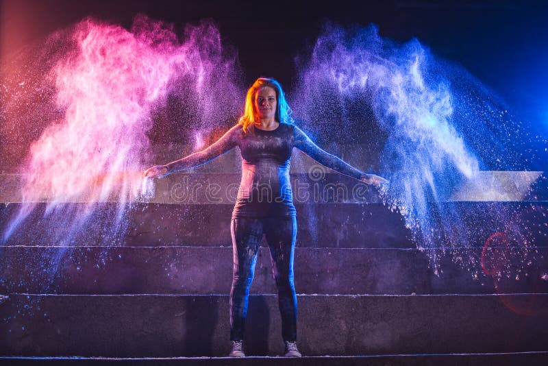 La donna incinta getta la polvere di colore nella forma delle ali di angelo fotografia stock libera da diritti La donna incinta getta la polvere di colore nella forma delle ali di angelo fotografia stock libera da diritti