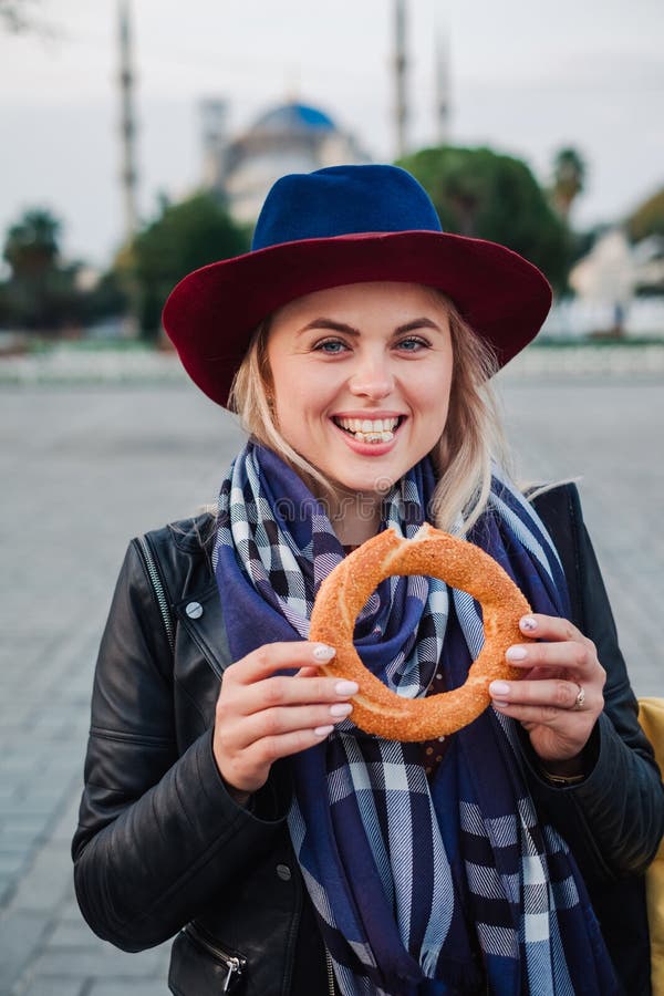 La donna mangia il simit turco irascibile o il bagel, viaggio di Costantinopoli, Turchia immagini stock La donna mangia il simit turco irascibile o il bagel, viaggio di Costantinopoli, Turchia immagini stock