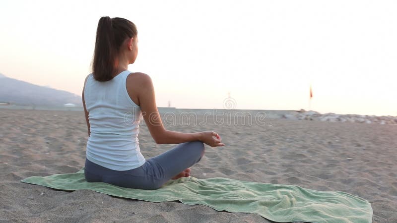 La donna medita di mattina su spiaggia stock footage