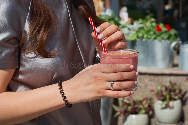 La donna sta tenendo la fragola fresca deliziosa nel mugon trasparente di vetro la tavola di legno bianca fotografia stock libera da diritti La donna sta tenendo la fragola fresca deliziosa nel mugon trasparente di vetro la tavola di legno bianca fotografia stock libera da diritti