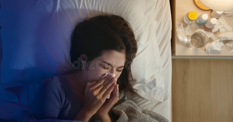 La donna starnutisce e ha la febbre immagini stock
