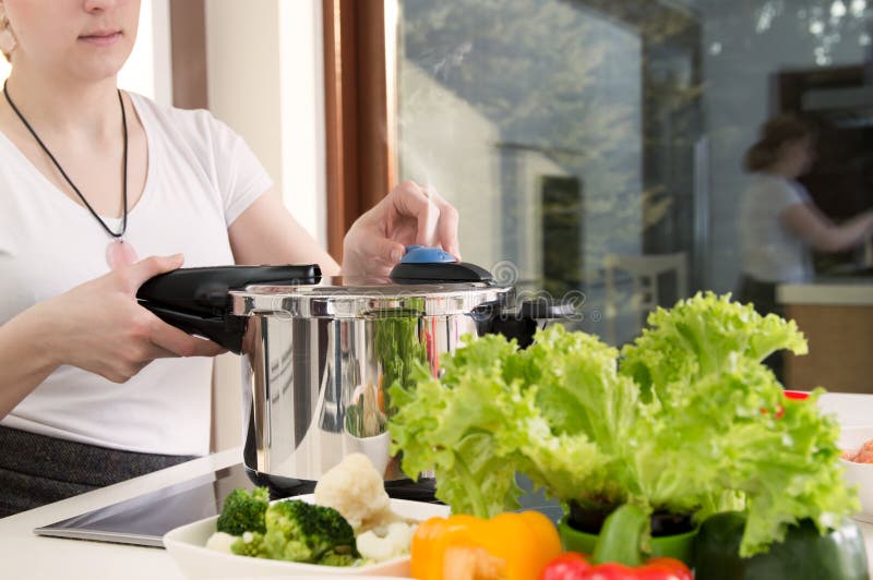 La donna utilizza la pentola a pressione per cucinare un pasto