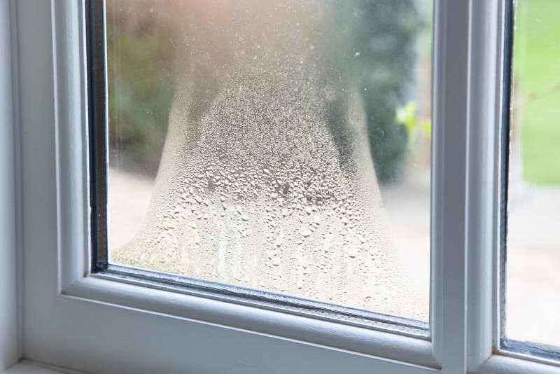 Close up of blown double glazed unit. Failed window glazing with condensation inside, UK. Close up of blown double glazed unit. Failed window glazing with condensation inside, UK