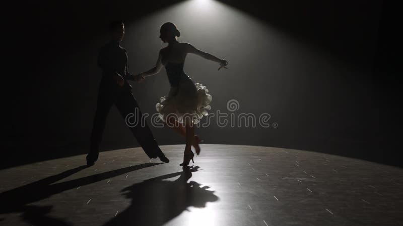 La elegante pareja de baile de la silueta en el centro de atención. metrajes