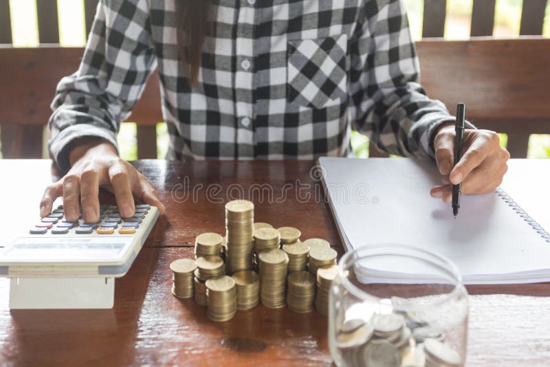 La empresaria con la calculadora que cuenta haciendo las notas, mano es wri imagenes de archivo La empresaria con la calculadora que cuenta haciendo las notas, mano es wri imagenes de archivo