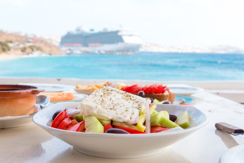 La ensalada griega fresca deliciosa sirvió para el almuerzo en el restaurante al aire libre con hermosa vista en el mar y el puer imágenes de archivo libres de regalías La ensalada griega fresca deliciosa sirvió para el almuerzo en el restaurante al aire libre con hermosa vista en el mar y el puer imágenes de archivo libres de regalías