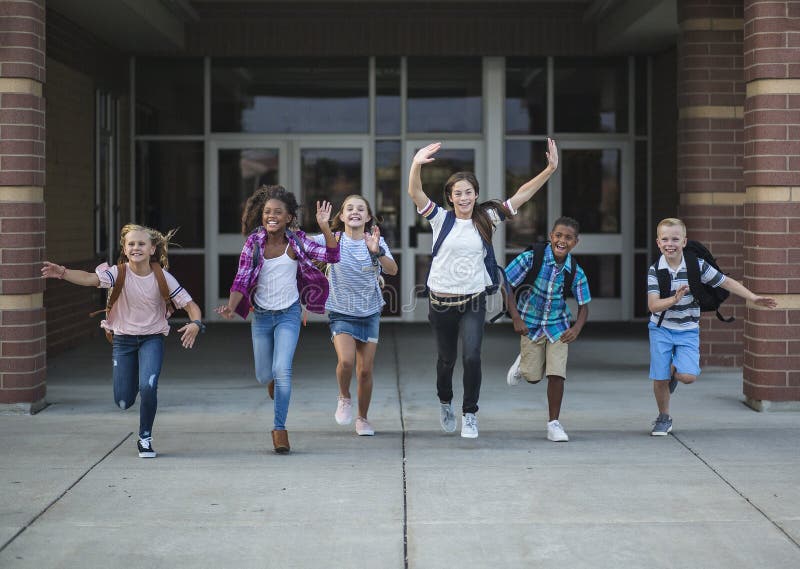 Group school school kids running as they leave the school building Back to school photo of a diverse group of children wearing backpacks and ready to go home from school. Group school school kids running as they leave the school building Back to school photo of a diverse group of children wearing backpacks and ready to go home from school