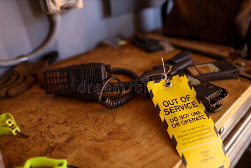 La etiqueta fuera de servicio amarilla atada en radio bidireccional quebrada del defecto en la tabla no utiliza u operación