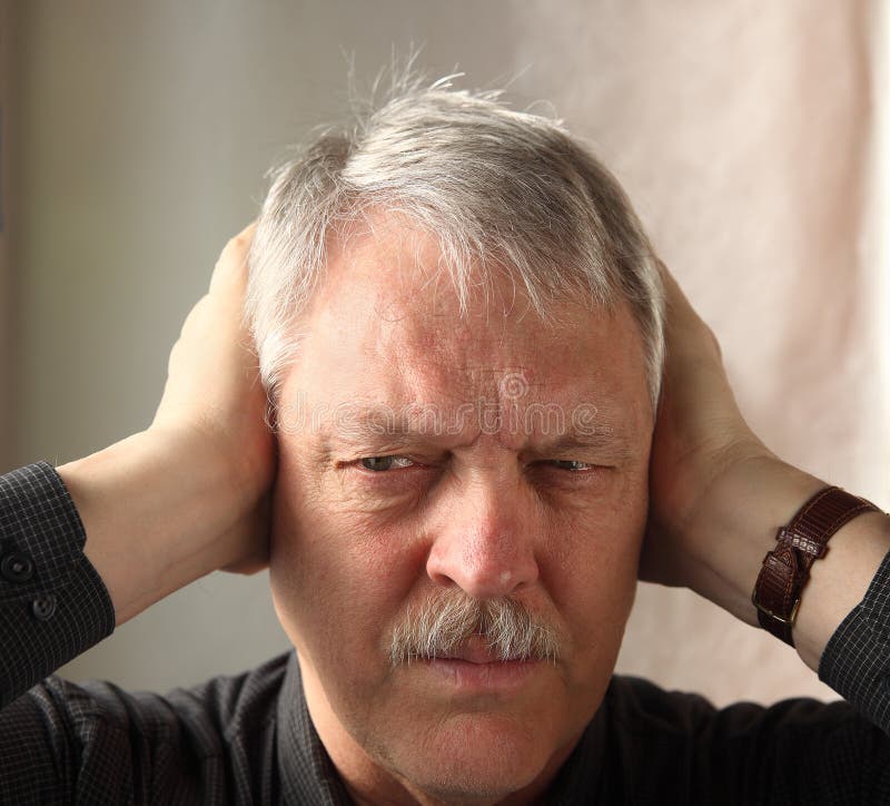 Older man shows irritation at loud noises. Older man shows irritation at loud noises