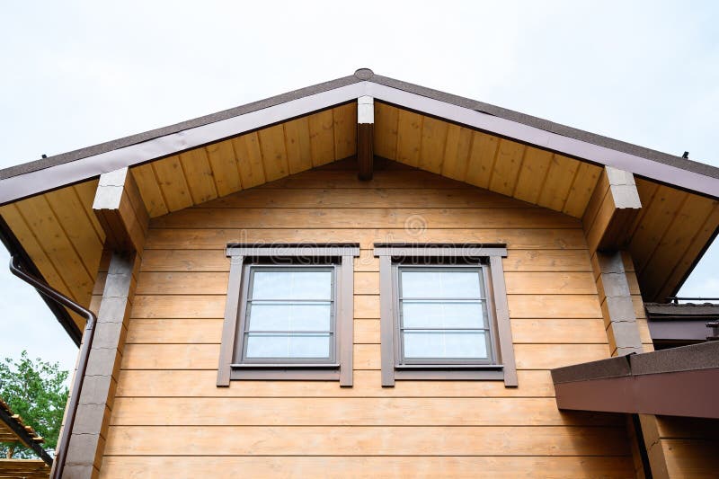 La facciata della nuova casa in costruzione, una casa di legno dipinta di colore naturale marrone immagine stock La facciata della nuova casa in costruzione, una casa di legno dipinta di colore naturale marrone immagine stock