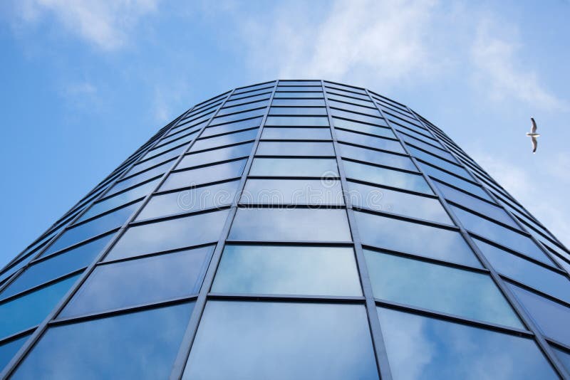 La fachada del edificio de oficinas con el cielo cubierto reflejó