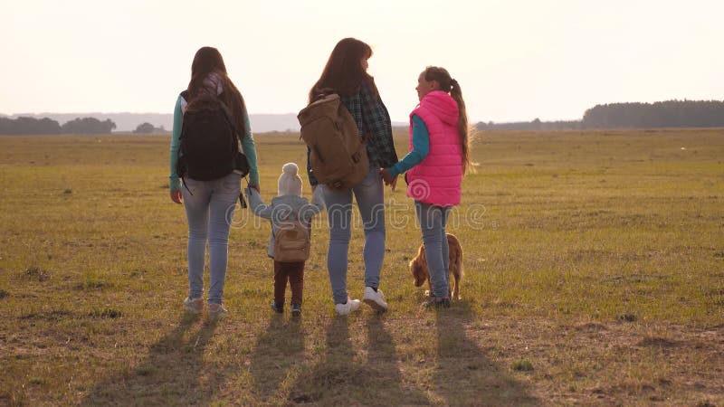 La famiglia con gli zainhi viaggia con un cane lavoro di squadra di una famiglia unita madre, derivati e turisti domestici degli stock footage