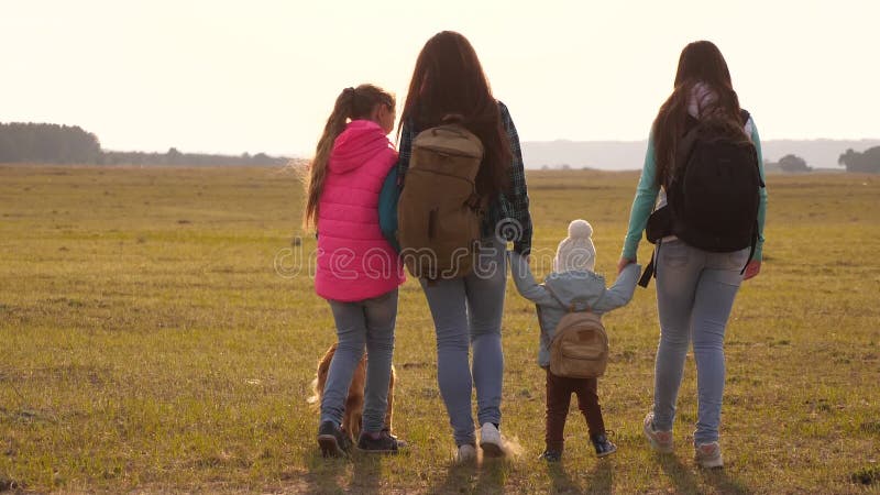 La famiglia con gli zainhi viaggia con un cane lavoro di squadra di una famiglia unita madre, derivati e turisti domestici degli archivi video