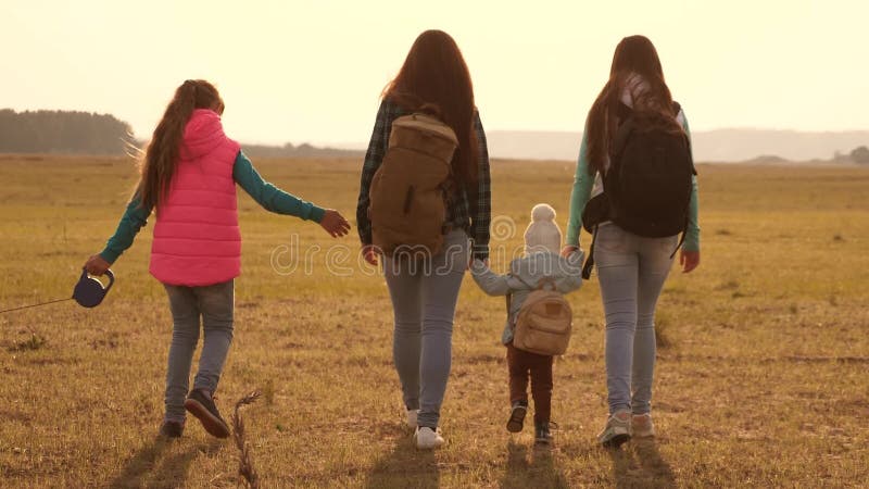 La famiglia con gli zainhi viaggia con un cane lavoro di squadra di una famiglia unita madre, derivati e turisti domestici degli stock footage