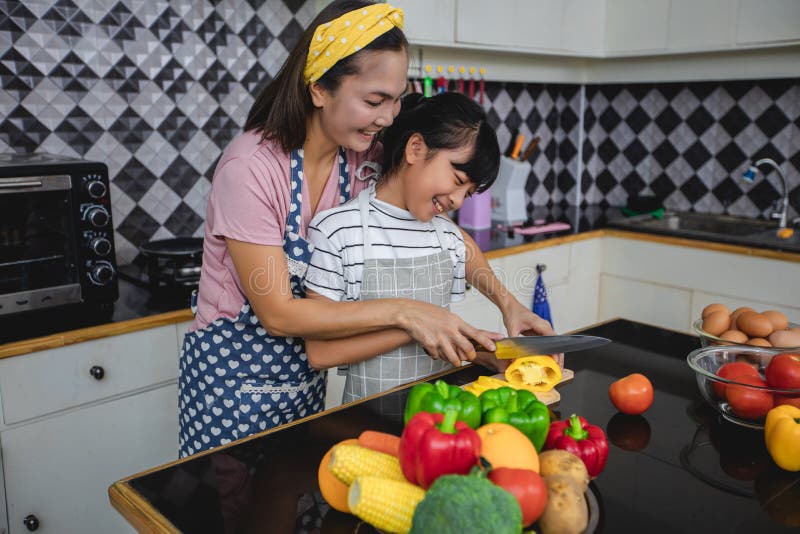 La famiglia felice ha il pap?, la mamma e loro piccola figlia cucinanti insieme nella cucina immagine stock La famiglia felice ha il pap?, la mamma e loro piccola figlia cucinanti insieme nella cucina immagine stock
