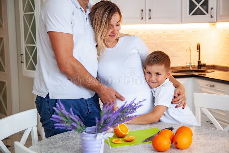 La famiglia sta avendo prima colazione e sta tagliando le arance alla tavola fotografie stock libere da diritti La famiglia sta avendo prima colazione e sta tagliando le arance alla tavola fotografie stock libere da diritti