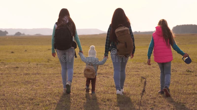 La famiglia viaggia con il cane attraverso le pianure e le montagne madre, figlie e turisti di animali domestici lavoro di squadr stock footage