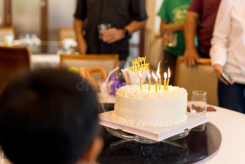 La familia con una torta de la vela celebra una fiesta de cumpleaños en un restaurante fotos de archivo libres de regalías La familia con una torta de la vela celebra una fiesta de cumpleaños en un restaurante fotos de archivo libres de regalías