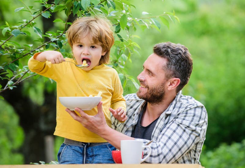 La familia disfruta de la comida hecha en casa Hijo del padre comer la comida y divertirse H?bitos de la nutrici?n Consumici?n de fotos de archivo La familia disfruta de la comida hecha en casa Hijo del padre comer la comida y divertirse H?bitos de la nutrici?n Consumici?n de fotos de archivo
