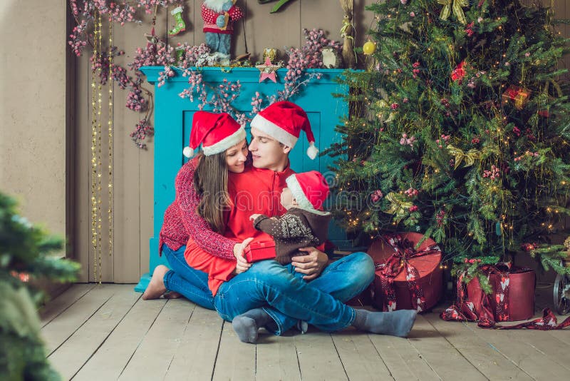 La familia feliz celebra la Navidad Mamá, papá e hijo en la Navidad imagen de archivo La familia feliz celebra la Navidad Mamá, papá e hijo en la Navidad imagen de archivo