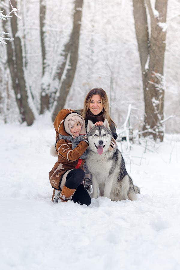 La familia feliz con los perros esquimales de los perros presenta en hermoso para la madera de la nieve Árboles en nieve imagenes de archivo La familia feliz con los perros esquimales de los perros presenta en hermoso para la madera de la nieve Árboles en nieve imagenes de archivo