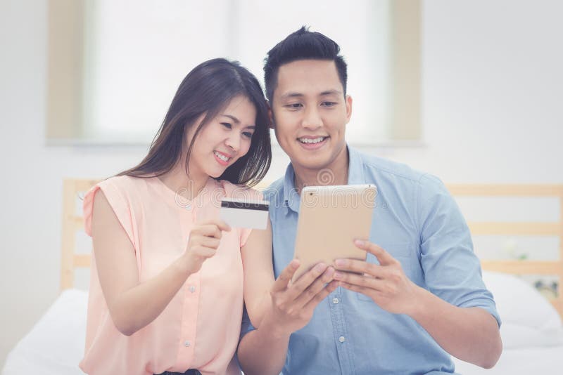 La familia feliz, los amantes asiáticos de los pares goza el usar de la tableta elegante fotografía de archivo La familia feliz, los amantes asiáticos de los pares goza el usar de la tableta elegante fotografía de archivo