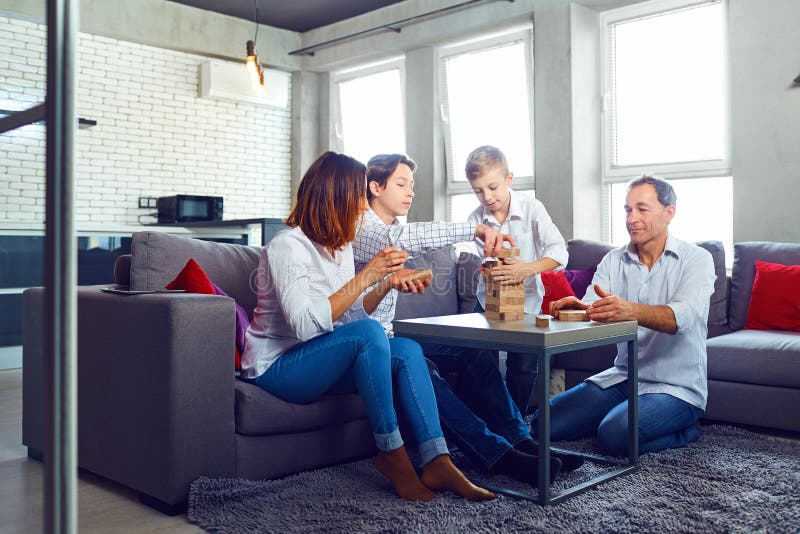 La familia juega a los juegos de mesa alegre mientras que se sienta en la tabla fotos de archivo libres de regalías La familia juega a los juegos de mesa alegre mientras que se sienta en la tabla fotos de archivo libres de regalías