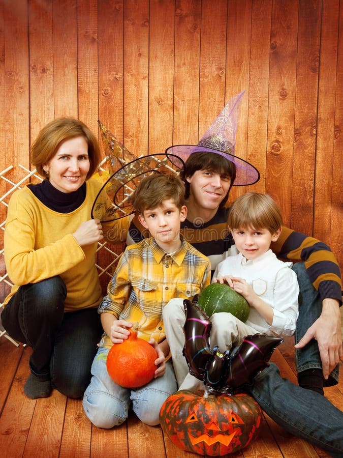 La familia se sienta con la calabaza tallada de Halloween fotografía de archivo libre de regalías La familia se sienta con la calabaza tallada de Halloween fotografía de archivo libre de regalías