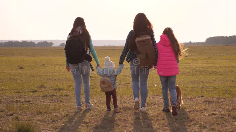 La famille avec des sacs? dos voyage avec un chien travail d'? quipe d'une famille tr? s unie m? re, filles et touristes? la maiso photographie stock libre de droits