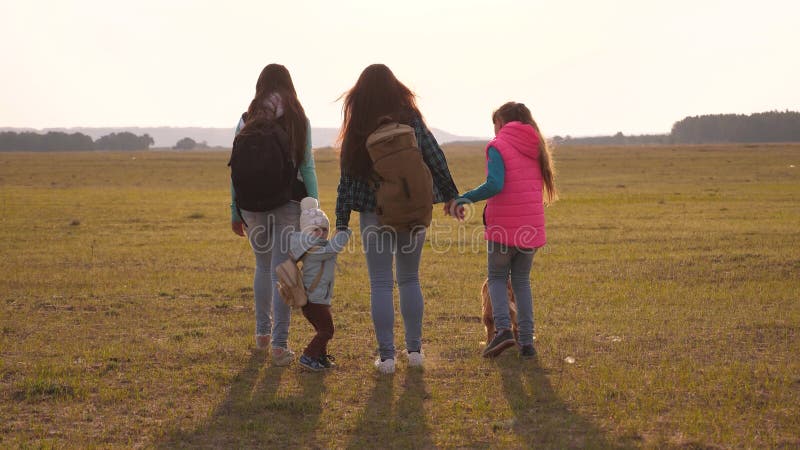La famille avec des sacs? dos voyage avec un chien travail d'? quipe d'une famille tr? s unie m? re, filles et touristes? la maiso photographie stock