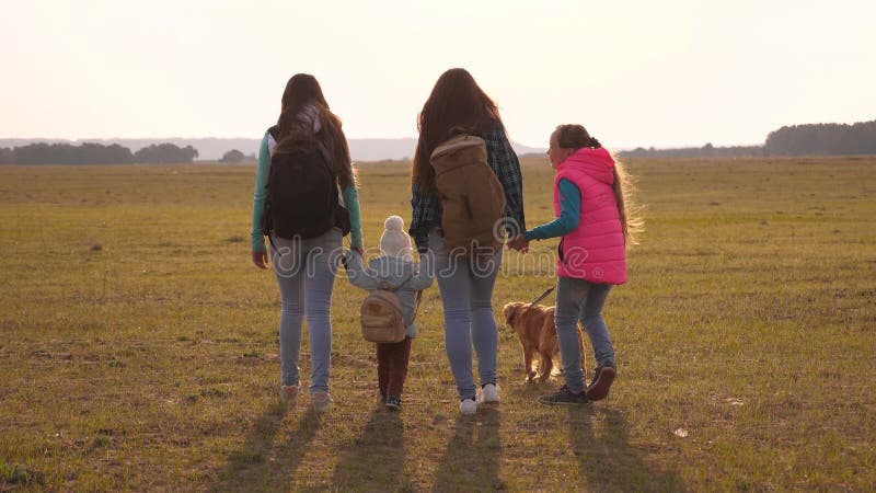 La famille avec des sacs? dos voyage avec un chien travail d'? quipe d'une famille tr? s unie m? re, filles et touristes? la maiso image stock