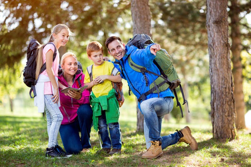 La famille de sourire sur augmenter montre avec la destination de doigt photo libre de droits La famille de sourire sur augmenter montre avec la destination de doigt photo libre de droits