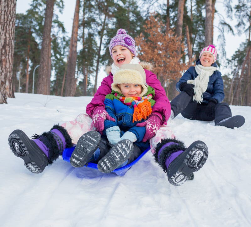 La famille drôle sledging dans le hiver-horizontal photo stock La famille drôle sledging dans le hiver-horizontal photo stock