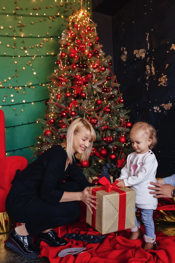 La famille heureuse avec un enfant célèbrent la nouvelle année près de l'arbre de Noël photo stock La famille heureuse avec un enfant célèbrent la nouvelle année près de l'arbre de Noël photo stock