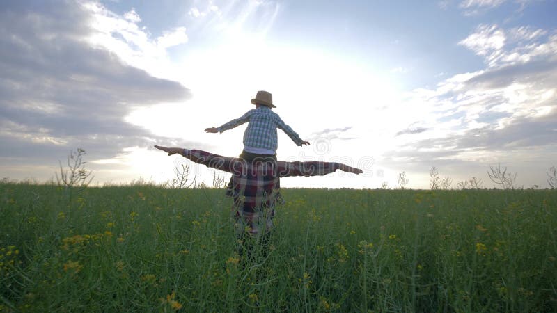 La famille heureuse, fils s'assied sur des ?paules de p?re et jouer avec la marche augment?e par bras sur le gisement de graine d