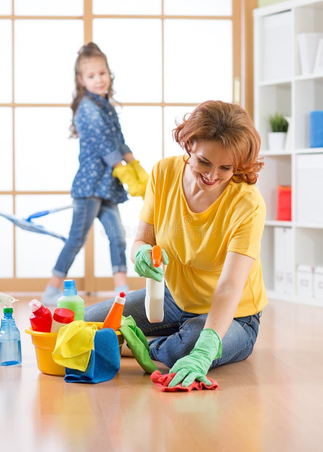 La famille heureuse nettoie la salle La mère et sa fille d'enfant font le nettoyage dans la maison photos libres de droits La famille heureuse nettoie la salle La mère et sa fille d'enfant font le nettoyage dans la maison photos libres de droits