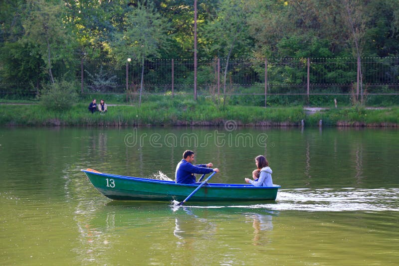 La famille naviguent dans le bateau à rames vert images libres de droits La famille naviguent dans le bateau à rames vert images libres de droits