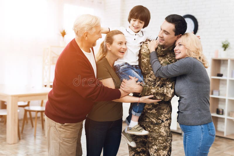 La famille rencontre un homme dans le camouflage à la maison photo libre de droits La famille rencontre un homme dans le camouflage à la maison photo libre de droits