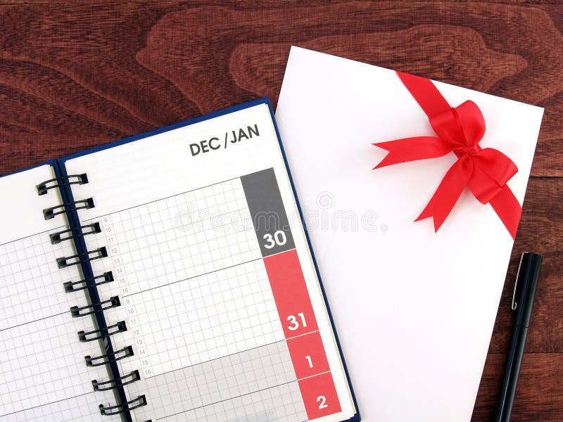 La fecha de diciembre y enero en la página del planificador del diario del calendario y el sobre blanco de la tarjeta de felicita imágenes de archivo libres de regalías La fecha de diciembre y enero en la página del planificador del diario del calendario y el sobre blanco de la tarjeta de felicita imágenes de archivo libres de regalías