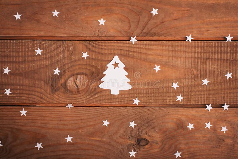 La Feliz Navidad carda decoraciones en el corte de papel sobre woodeno fotografía de archivo libre de regalías La Feliz Navidad carda decoraciones en el corte de papel sobre woodeno fotografía de archivo libre de regalías