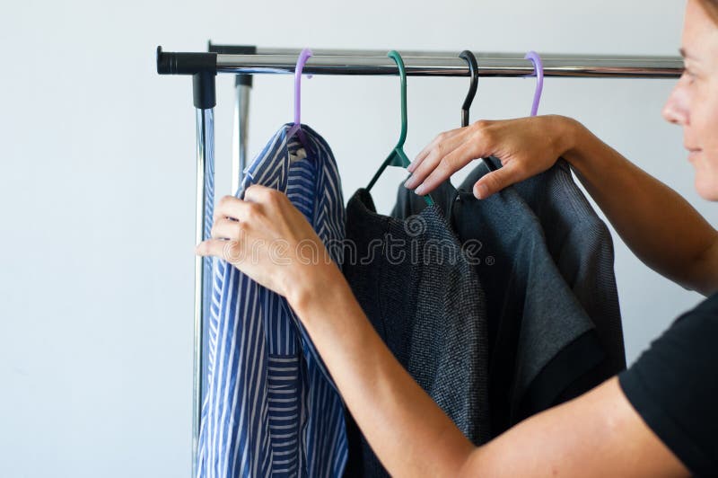 La Femme Accroche La Veste Sur Le Cintre Photo stock - Image du