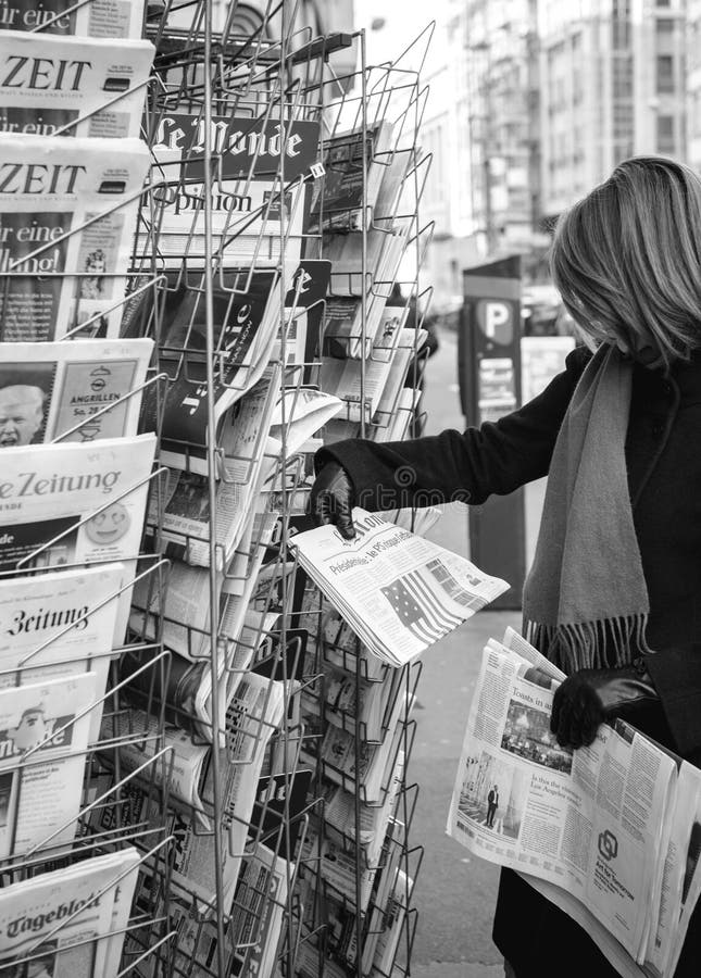 La femme achète un journal de presse de Français de Le Monde d'un newssta image libre de droits La femme achète un journal de presse de Français de Le Monde d'un newssta image libre de droits