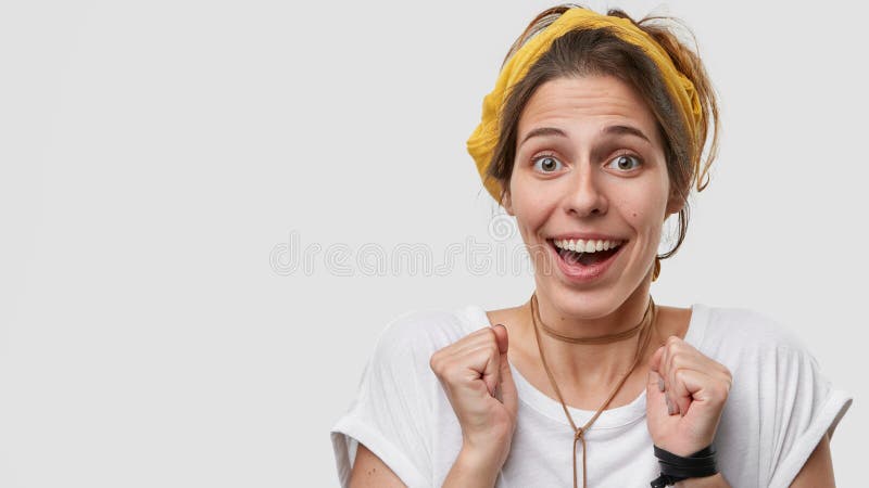 La femme agréable à regarder positive avec l'expression heureuse, maintient des mains serrées, des anticiptaes pour le miracle, d photo libre de droits