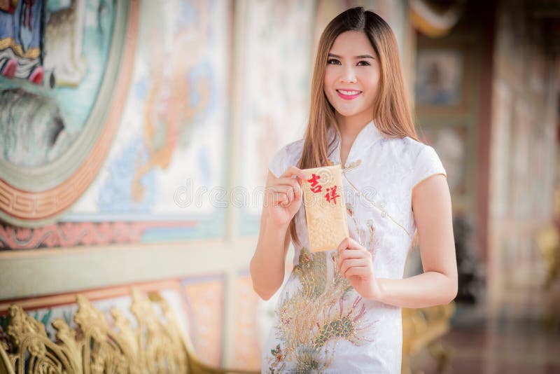 La femme asiatique dans le Chinois habillent juger le couplet 'heureux' (Chine photographie stock libre de droits La femme asiatique dans le Chinois habillent juger le couplet 'heureux' (Chine photographie stock libre de droits