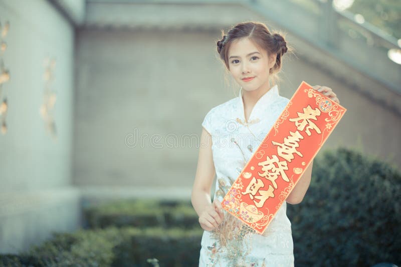 La femme asiatique dans le Chinois habillent juger le couplet 'lucratif' (C photographie stock libre de droits La femme asiatique dans le Chinois habillent juger le couplet 'lucratif' (C photographie stock libre de droits