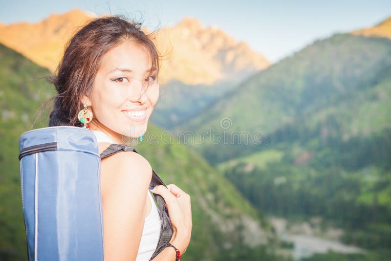 La femme asiatique heureuse avec le tapis de yoga allant à la forme physique s'exerce images libres de droits La femme asiatique heureuse avec le tapis de yoga allant à la forme physique s'exerce images libres de droits