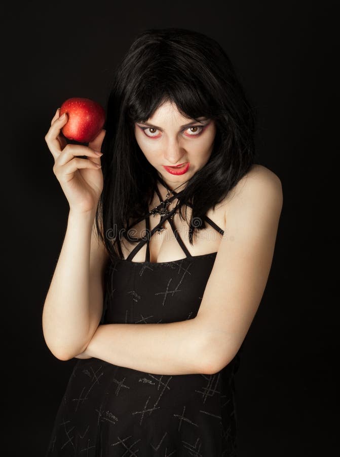 La femme avec veille de la toussaint composent la pomme de rouge de fixation photographie stock libre de droits La femme avec veille de la toussaint composent la pomme de rouge de fixation photographie stock libre de droits