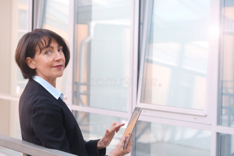 La femme d'affaires m? re utilise le comprim? sans fil sur la rue urbaine photos stock