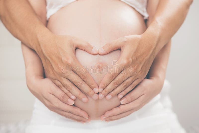 La Femme Enceinte Et Son Mari Se Frottent La Main Dans Le Ventre Le Coeur En Forme De Montre L Amour Pour Le Bebe Dans Le Ventre Image Stock Image Du Horizontal
